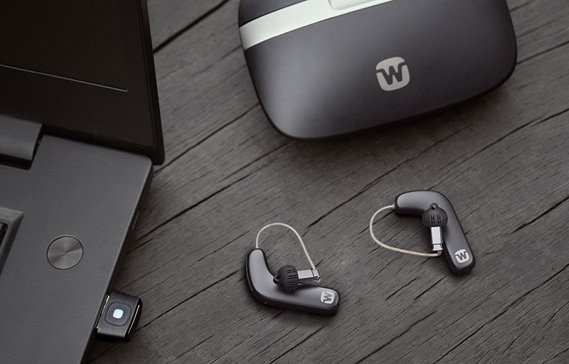 Widex hearing aids with charging case on desk