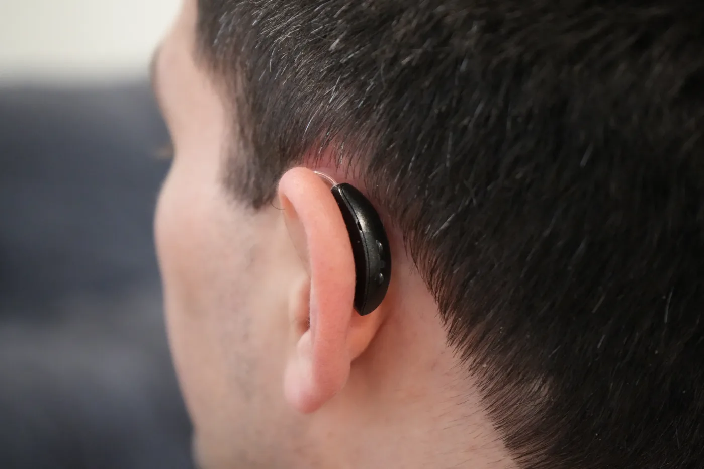A discreet behind-the-ear hearing aid worn comfortably and barely noticeable